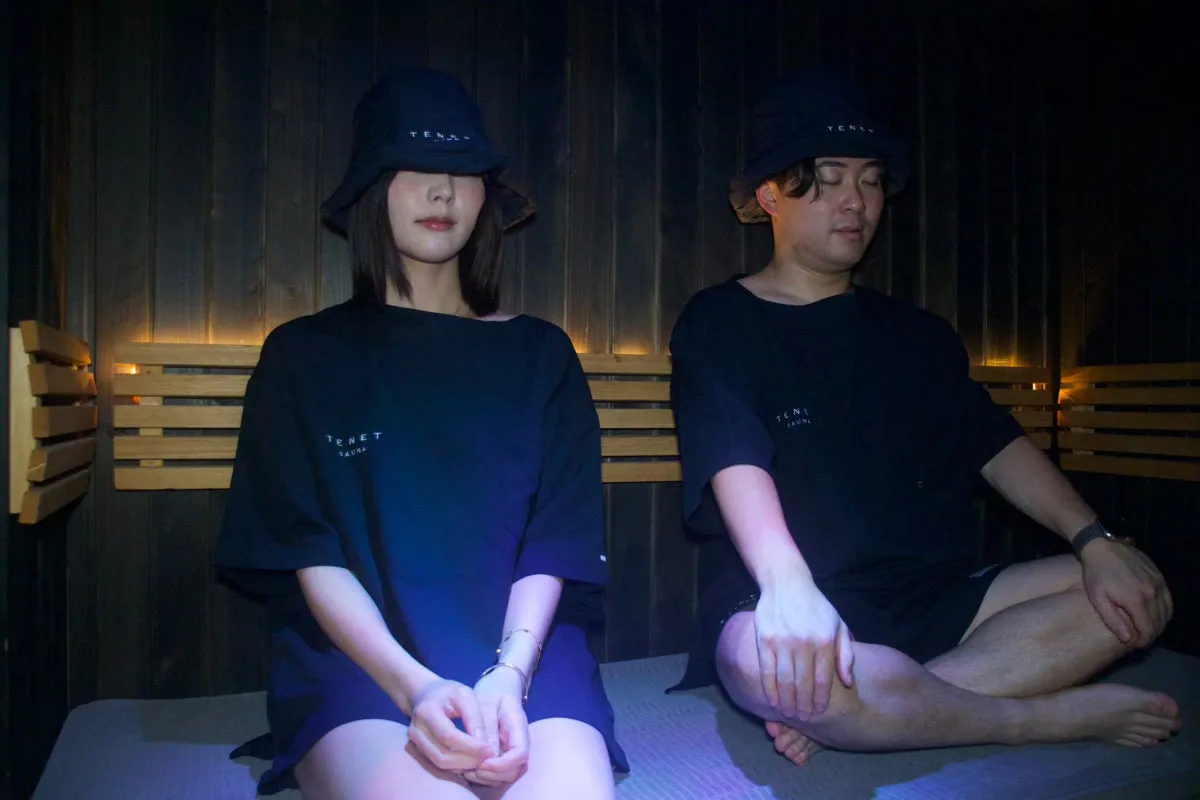 館内着を着て個室サウナでくつろぐ男女